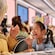 A young girl laughing with her family as they enjoy a meal at Animator’s Table on the Disney Adventure cruise ship